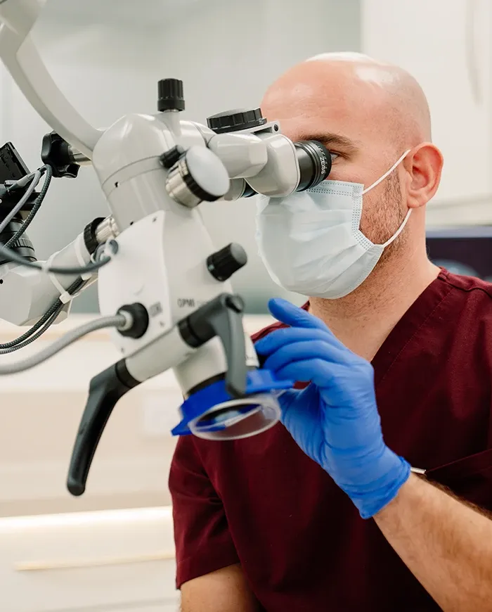 A Broad Street Dental dentist working through a dental operating microscope