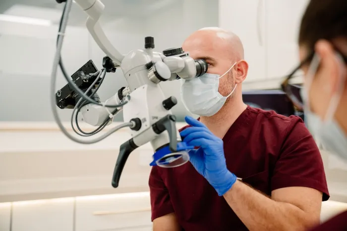 A dentist at the microscope preparing for a laser-assisted implant procedure