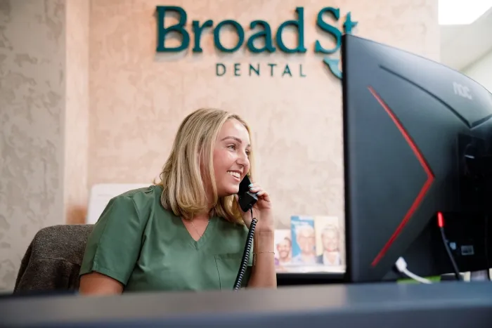The Broad Street Dental reception desk at 29 Broad Street, St Helier, with the practice sign on the wall